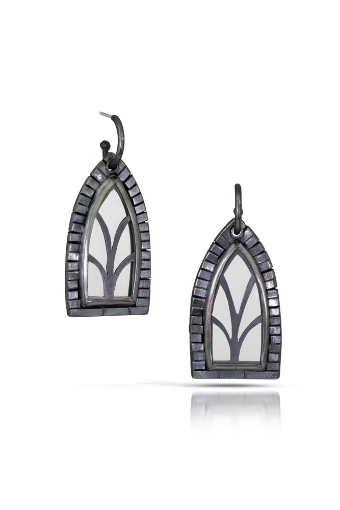 A pair of one of a kind statement window shaped earrings with tall arch panels and decorative brick elements framing the windows. Oxidized sterling silver with crystal quartz for window panels.